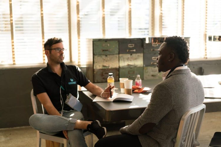 2 men talking at a desk