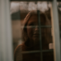 photo of a woman's scared reflection in a window