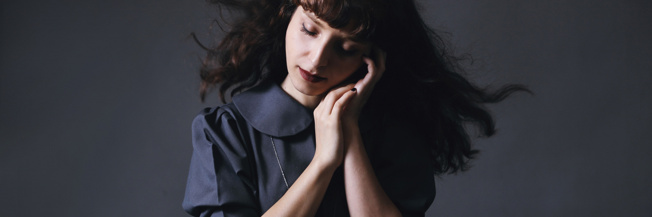 SAINT: Why This New Depression Treatment Gives Me Hope photo of a woman with her eyes closed and hands raised to her cheek