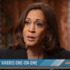 Kamala Harris looking at the camera during an interview on the "Today Show." She looks distraught and is sitting with a library in back of her. Her suit is black.