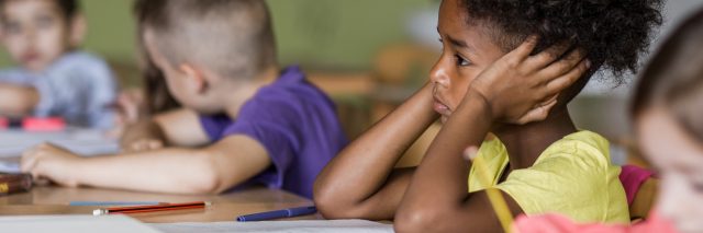 Sad Black child in classroom.