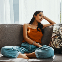 Woman looking thoughtful while relaxing on the sofa at home