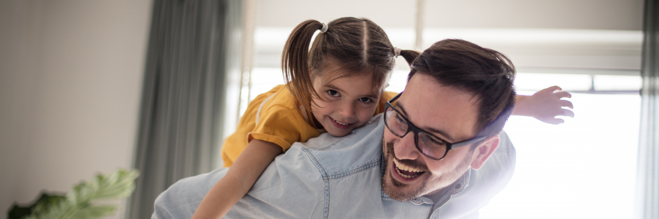 Free as can be. Father and daughter having fun at home.