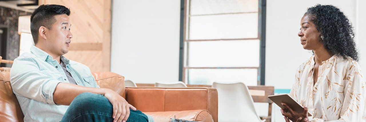 Insights Into What Good Trauma Therapists Are Like Therapist holding notepad and listening to patient