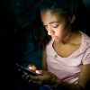 Lonely girl texting on mobile phone late at night