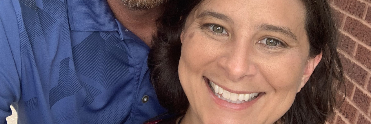 Communicating Your Needs to a Partner to Cope With Hard Anxiety Days A white woman with brown hair stands beside her partner, a white man.