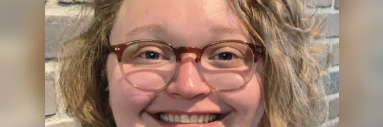 What Helps a Woman in Her Twenties Manage Bipolar Disorder Close-up photo of a white woman with shoulder-length wavy blonde hair and wearing glasses.