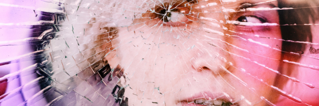 View of woman's face as if behind cracked glass