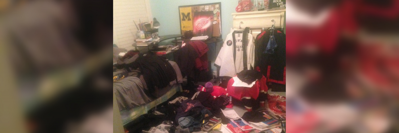 How Disorganization and Clutter Can Be a Side Effect of Depression A messy bedroom with clothes all over the floor and bed. There's a lot going on here. There's a poster on the wall, an da dress behidn some more clothes. Boxes of clutter as well are on the floor. The wall is blue. It's a very very messy room.