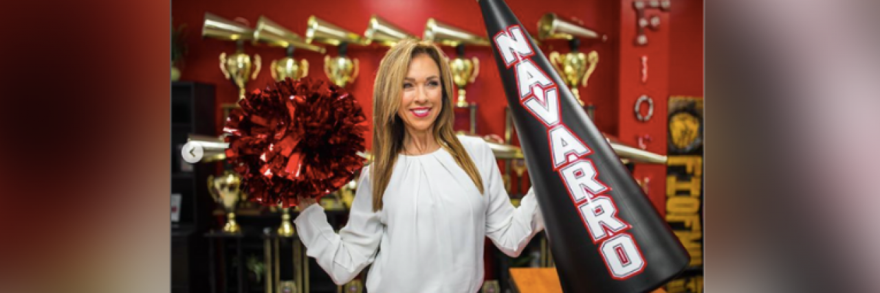 Monica Aldama, coach in Netflix series "Cheer," holds a pompom and megaphone