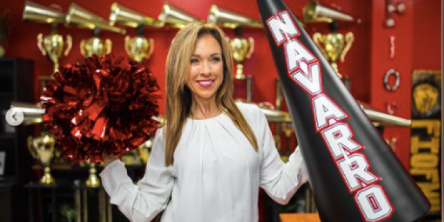 Monica Aldama, coach in Netflix series "Cheer," holds a pompom and megaphone