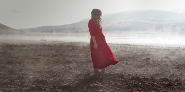 The Grief That Comes Naturally When Your Life Is Changed by Illness A woman standing in a field of dirt