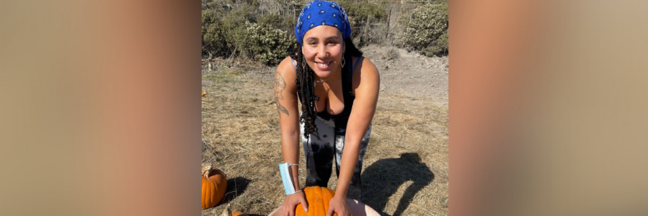Looking Back on Coping With Grief and Schizoaffective Disorder Photo of contributor in field with a wheelbarrow and pumpkin