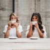 Two women sipping from coffee mugs