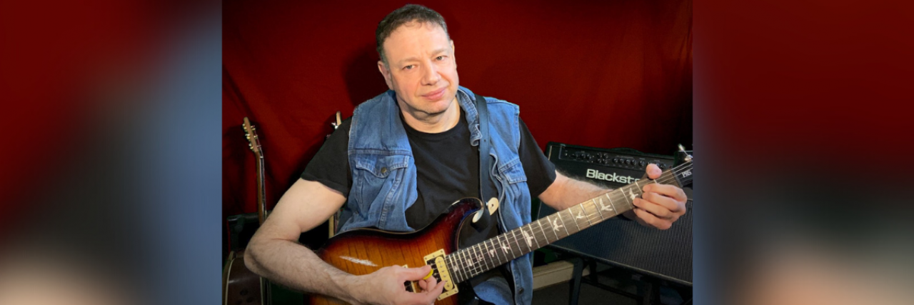 3 Doses of Music as Medicine Photo of musician Jason Didner holding a guitar