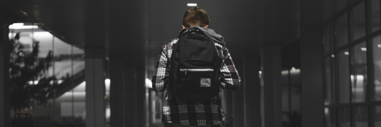 The Sign That I Was Depressed, Lonely, and Bullied in Middle School photo of a young boy walking alone through hallway at school alone with a backpack and his head down