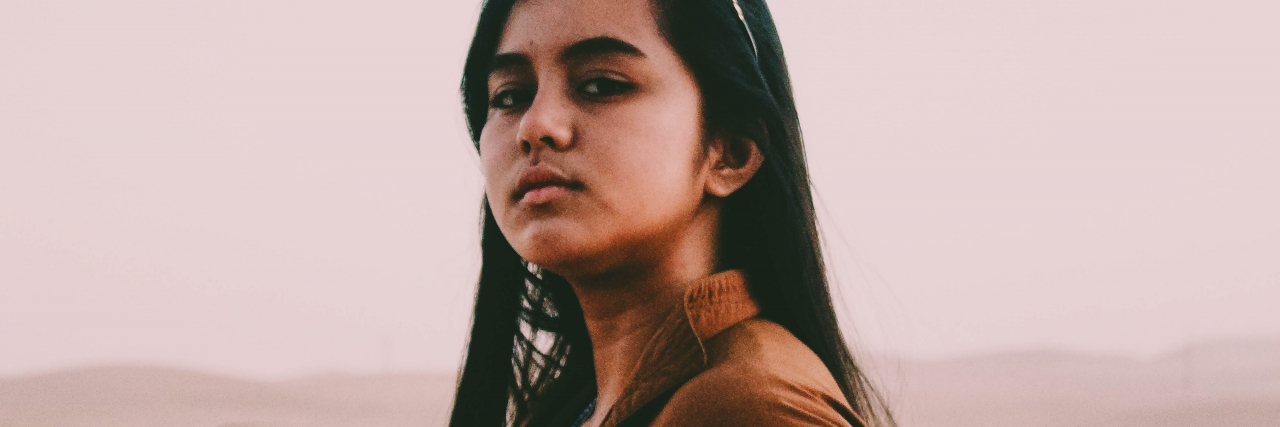 Do I Have ADHD, Trauma, or Both? photo of a woman looking into camera with a serious expression