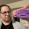 photo of the author, woman holding a smiling plush of an ovary and looking confused