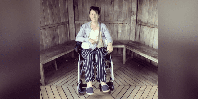 8 Weird Things That Can Happen When You Are a Wheelchair User Contributor in her wheelchair in front of wooden paneled wall and benches