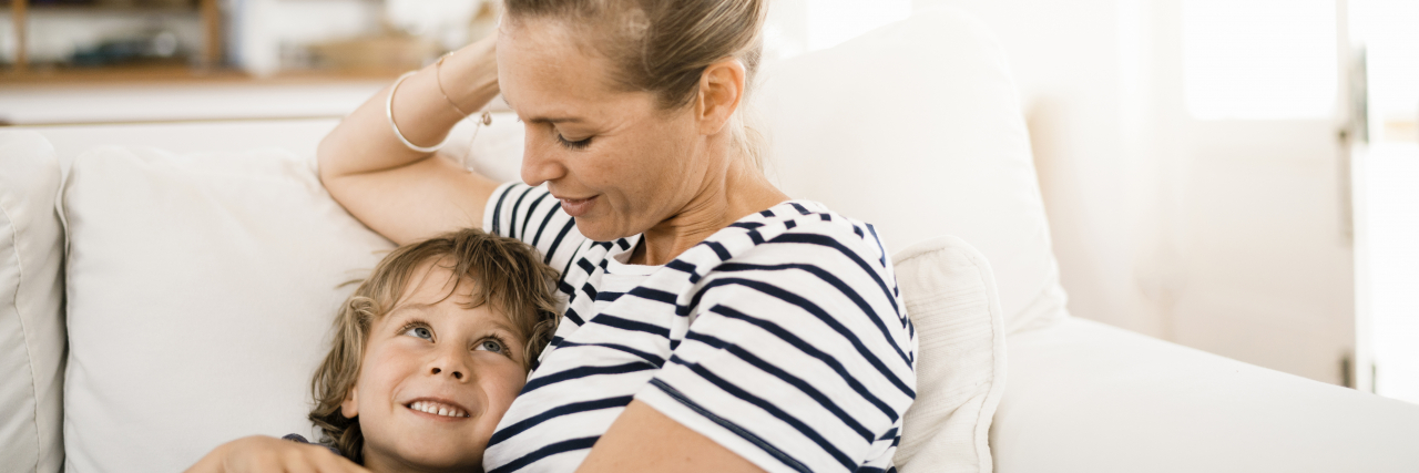 Realizing That My Son's ADHD Diagnosis Isn't 'My Fault' A woman with blonde hair wearing a striped shirt holds a young boy with blonde hair.