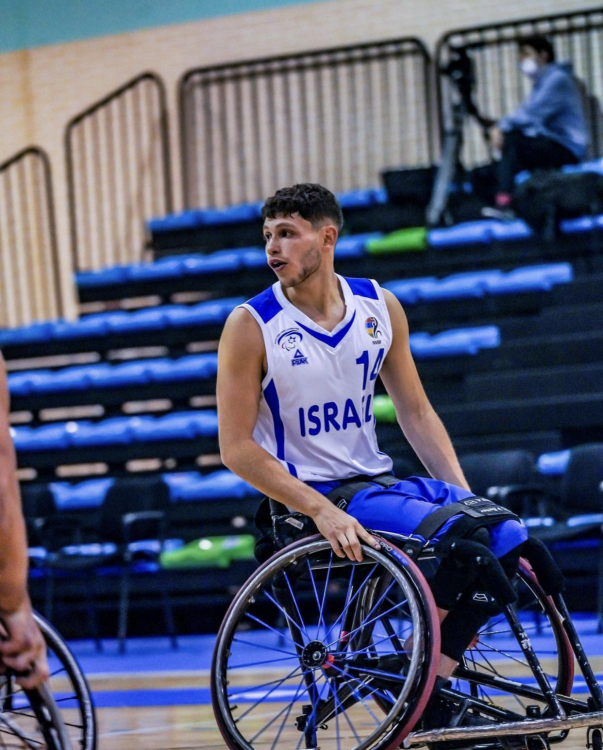 Amit playing wheelchair basketball.