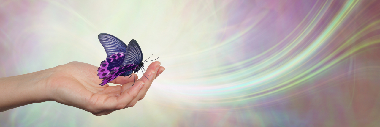 Female hand with a purple butterfly.