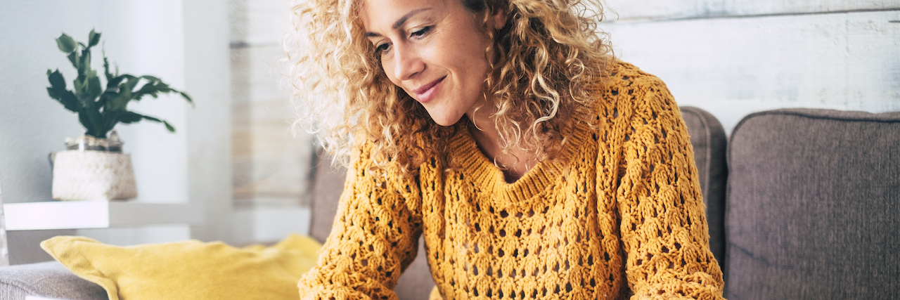 How I'm Coping With a Relapse in Eating Disorder Recovery Woman with auburn hair sitting at laptop and holding coffee mug