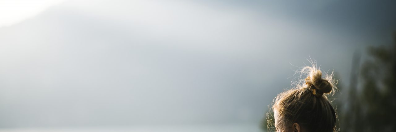 We Need to Talk About Chronic Illness and Suicidal Thoughts Woman at lake.