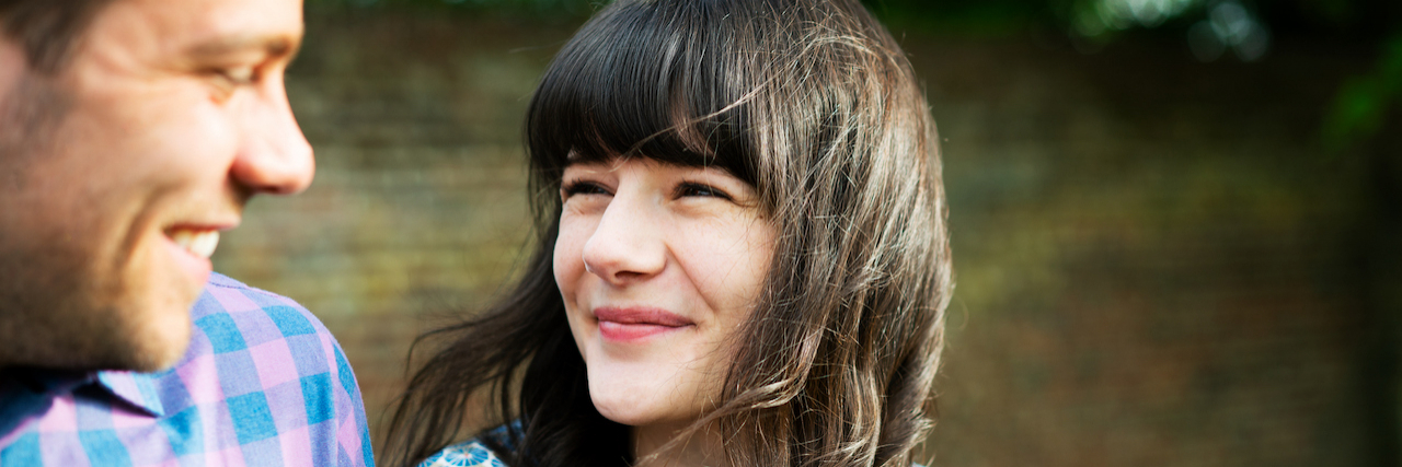 A Letter to Myself Before My Husband Was Diagnosed With Thyroid Cancer Woman and man looking at each other and smiling, outside