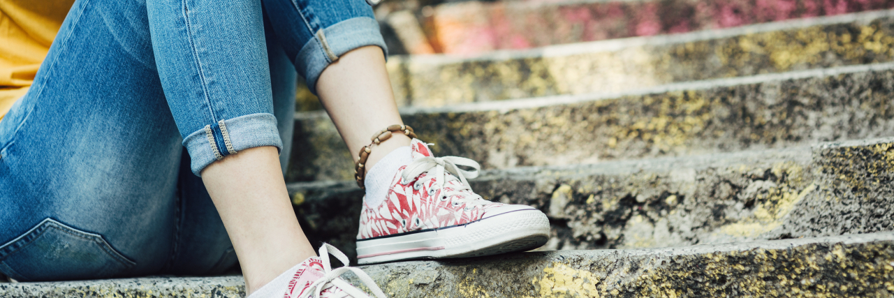 Undiagnosed: My Endless Quest for an Answer teen girl sitting on steps with cell phone in her hand
