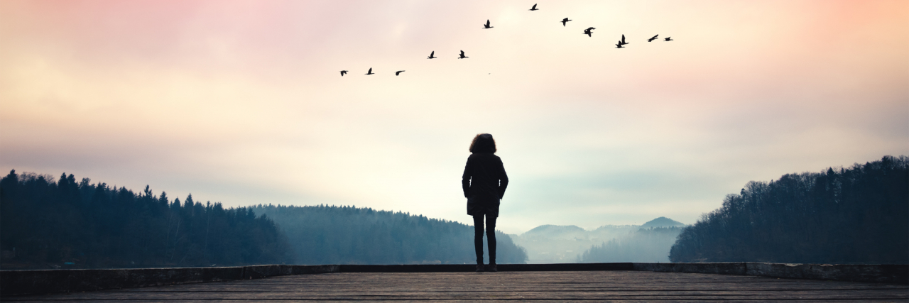 Raising Awareness for Anorexia and Eating Disorder Recovery Silhouette of woman standing on jetty and watching sunrise by the lake.