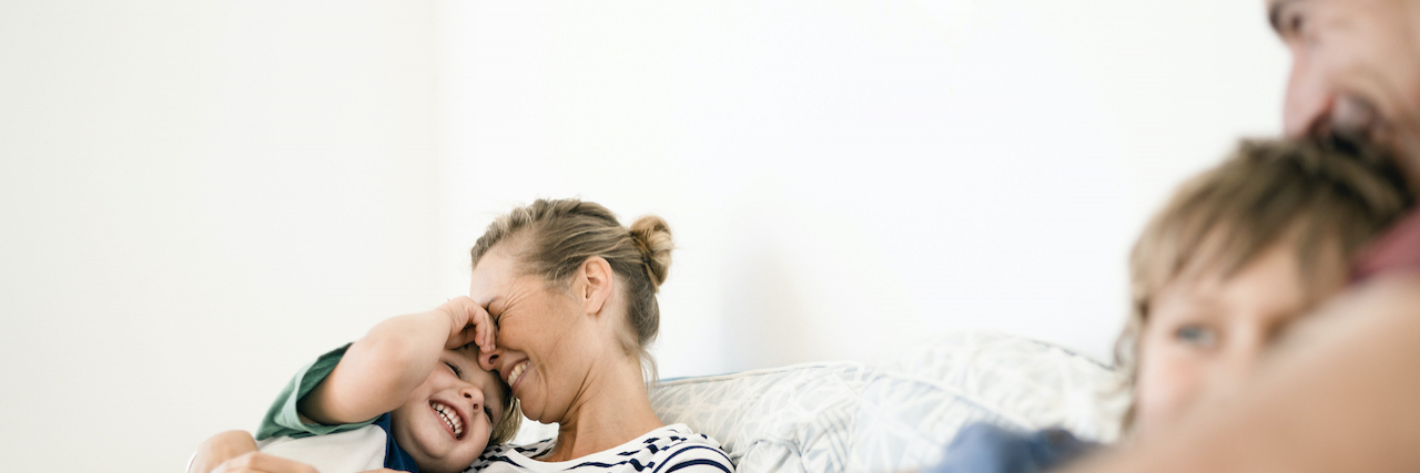 When Genetics Complicates Family Planning Mother and father snuggling on couch with their two sons