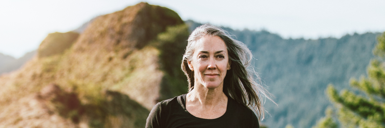 How Cloacal Exstrophy Can Affect Sex and Relationships Middle-aged woman with mountains in background.