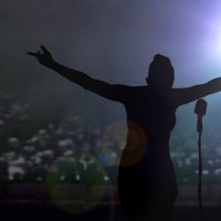 Women bowing on stage after a concert under bright spotlights