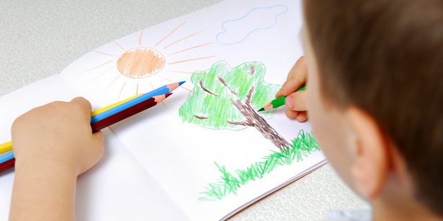 Boy drawing a tree.