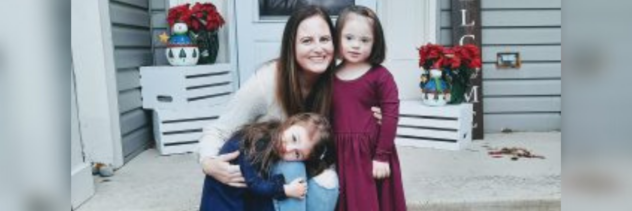5 Things No One Tells You About Premenstrual Dysphoric Disorder Author (young woman) with arms wrapped around her 2 young daughters, smiling