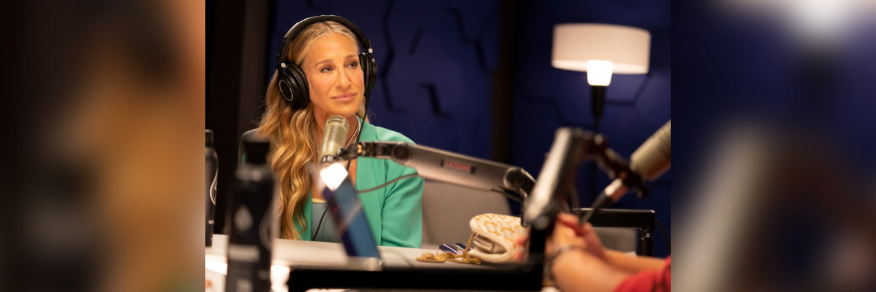 Carrie from "And Just Like That" with headphones on in a recording studio for her podcast
