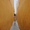 Woman walking down a narrow alley.