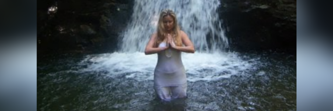 To the Newly Diagnosed Ehlers-Danlos Syndrome Warrior Contributor standing in front of waterfall holding her hands in prayer position