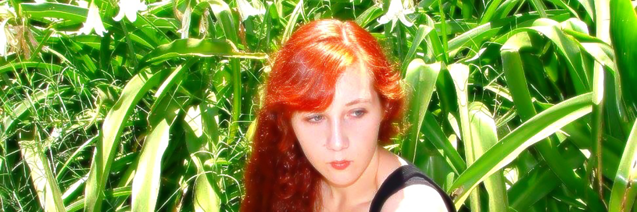 The Shame I Felt as a Teen With a Congenital Heart Defect Amelia as a teen, sitting in a field.