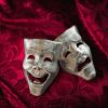 Theater masks, drama and comedy on a red curtain.
