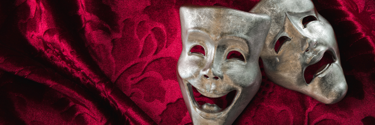 Attending Realwheels Acting Academy as a Performer With a Disability Theater masks, drama and comedy on a red curtain.
