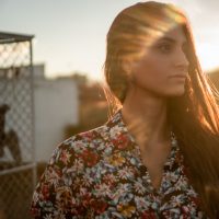 Woman of color on rooftop at sunset