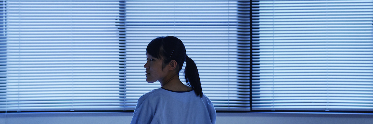 The Danger in Basing Eating Disorder Recovery Around Numbers Asian woman sitting in bed in medical facility