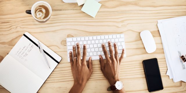 Overcoming Barriers to Employment When Living With Schizophrenia  Person working at a desk with to-do list. Close up of hands on keyboard.
