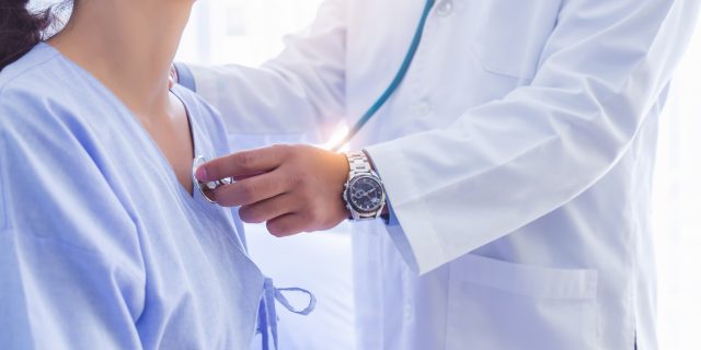 Doctor using stethoscope, checking heart