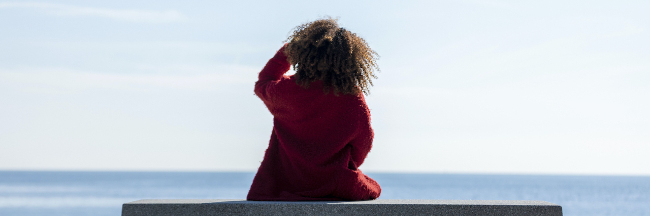 Stopping Sexual Predators Before They Find a Victim Rear view of a young black woman sitting on a bench while looking away to the horizon over the sea