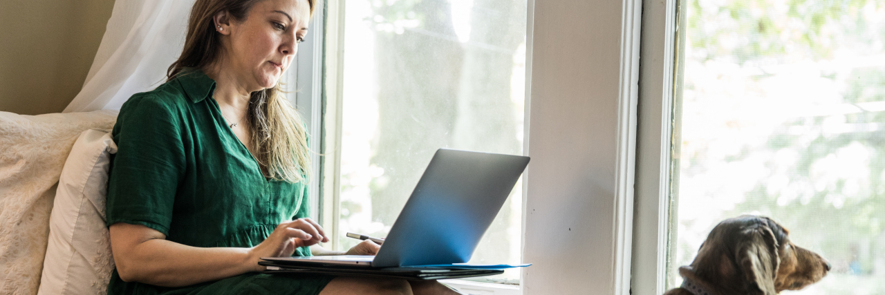 Why Having a Boss Who Understands Migraine Is So Important Woman working at home with dog.