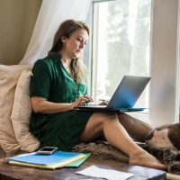 Woman working at home with dog.