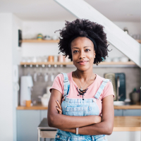 Portrait of a Black woman standing and looking into the camera at home